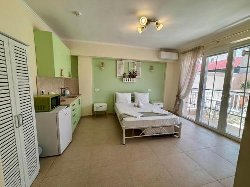 a kitchen with a bed in a room with green walls at Orea Boutique Studios in Asprovalta