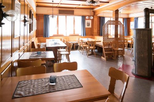 a restaurant with wooden tables and chairs and windows at Berggasthaus Voralp in Grabs