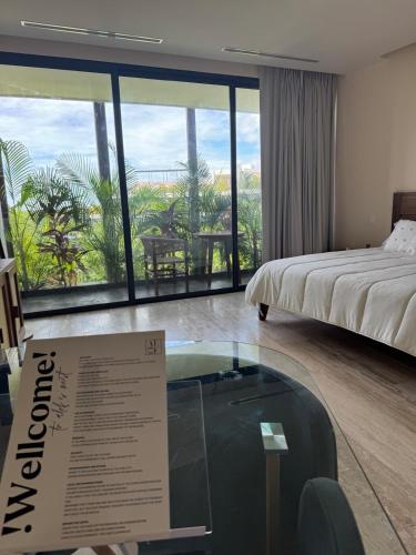 a hotel room with a bed and a glass table at Alof Studio in the Jungle in Tulum