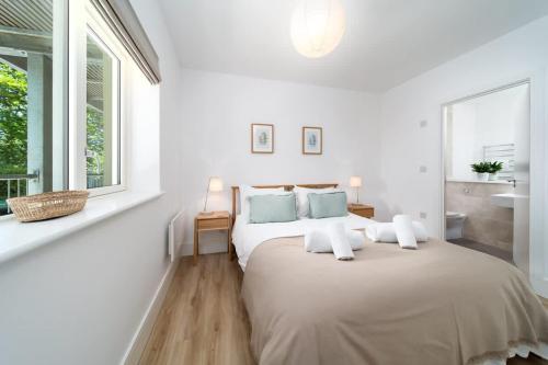 a white bedroom with a large bed and a window at Tree Top - Perfect Apartment For Relaxing Getaway, Balcony, Parking in Lynmouth