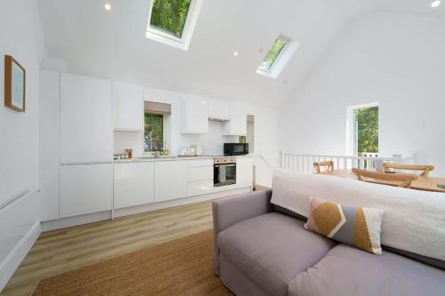 a living room with a couch and a kitchen at Tree Top - Perfect Apartment For Relaxing Getaway, Balcony, Parking in Lynmouth