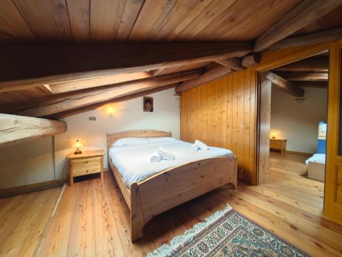 a bedroom with a bed and a wooden ceiling at Hostdomus - Flower Loft in Cesana Torinese