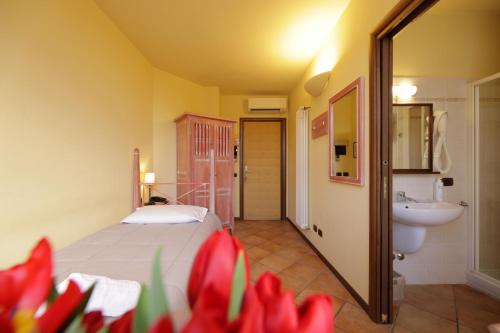 a bedroom with a bed and a bathroom with a sink at Hotel Locanda dell'Oca Bianca in Como