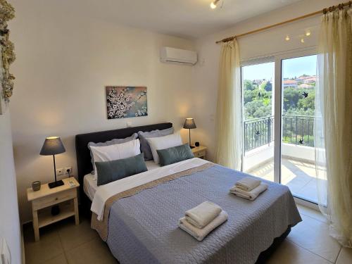 a bedroom with a large bed and a balcony at Lakithra Apartments in Kefallonia