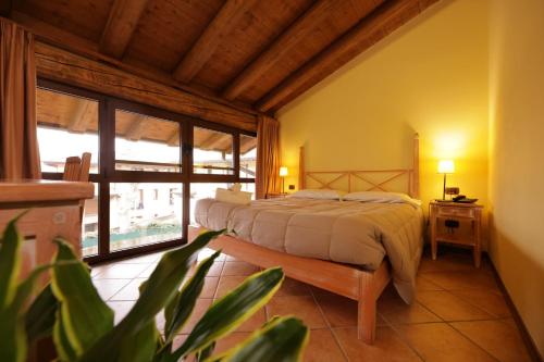 a bedroom with a bed and a large window at Hotel Locanda dell'Oca Bianca in Como