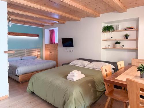 a bedroom with two beds and a desk and a table at Dolomiti Nest in Tesero