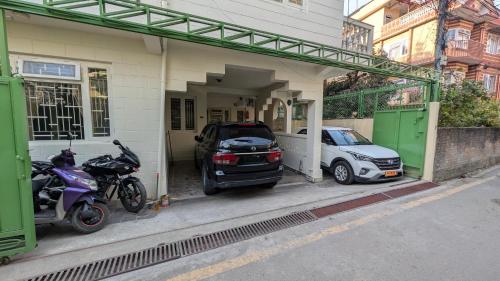 two motorcycles and a car parked in a garage at Tuyu Chhye in Kathmandu