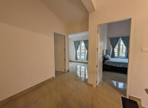 an empty room with a bed and two windows at Sintra Villa in Meppādi