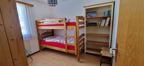 a bedroom with two bunk beds and a book shelf at Pic-Chaussy B14 in Les Mosses