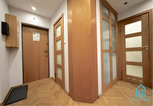 a hallway with two wooden doors and a television at Deer Room - 5 Minutes to Sopot Molo & Seaside in Sopot