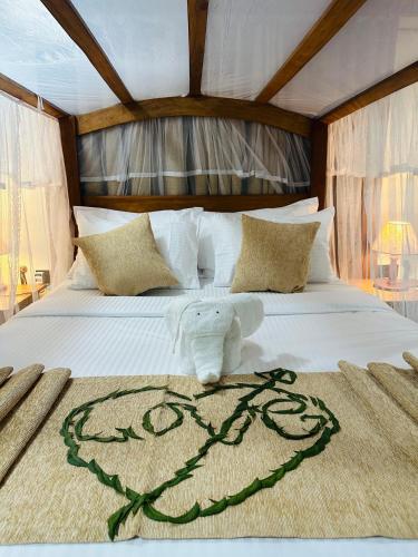 a white bed with a stuffed animal on it at Green Heaven Sigiriya in Sigiriya