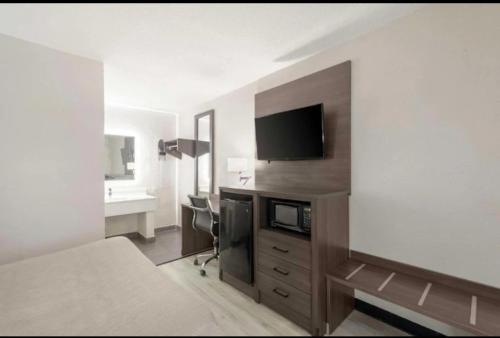 a hotel room with a bed and a desk and a television at Downtown Inn & Studio Suites in Memphis