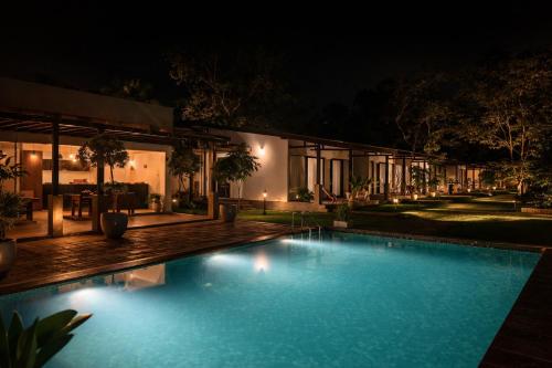 a swimming pool in front of a house at night at Maho Boutique Hotel in Anuradhapura