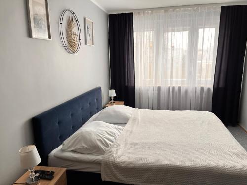 a bedroom with a bed and a window at Apartament Central Wałcz Residence in Wałcz