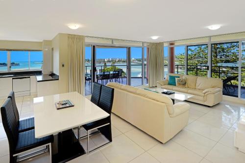 a living room with a couch and a table at Sunrise Luxury Apartments in Tuncurry