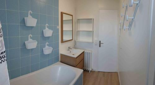 a bathroom with a tub and a sink and a mirror at Spacieux T5 confort 9 pers in Angers