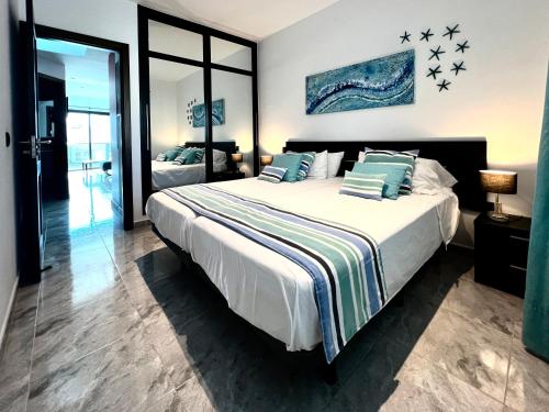 a bedroom with a large bed with blue pillows at Atlantic Green 3 Apartment, Terrace, Solarium and Spa in El Cotillo