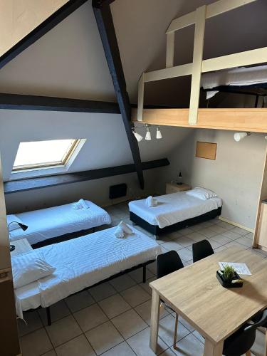 a room with two beds and a table and a loft at Condo Gardens Antwerp in Antwerp