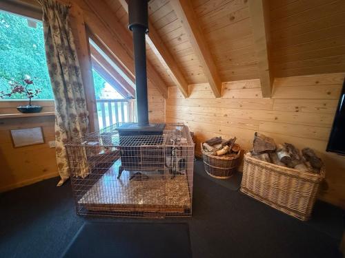 a room with a woodburning stove in a cabin at Alpine Lodge in Pentney
