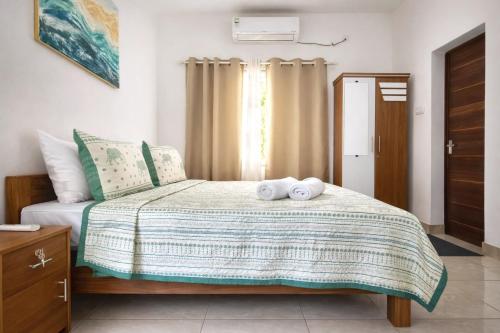 a bedroom with a bed with two towels on it at Gypsy Walker in Varkala