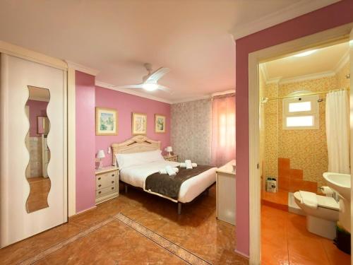 a bedroom with a bed and a bathroom with a sink at Beach House Victoria - Beachside - Playa Rincón in Rincón de la Victoria