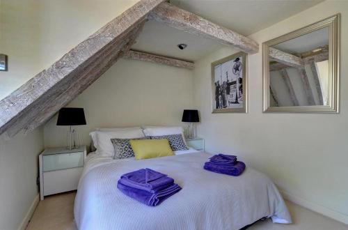 a bedroom with a white bed with two purple bags on it at 2 Bed in Tunbridge Wells oc-tw660 in Royal Tunbridge Wells