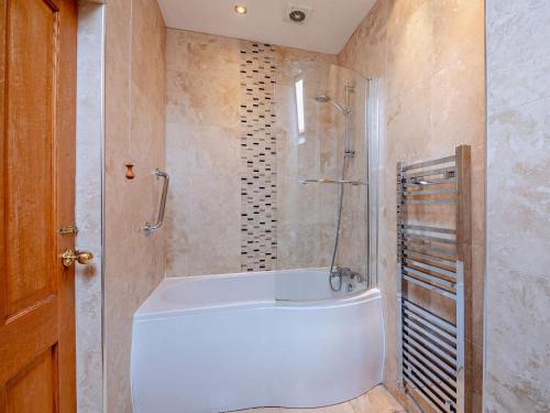 a bathroom with a white tub and a shower at 3 Bed in Keswick oc-sz135 in Threlkeld