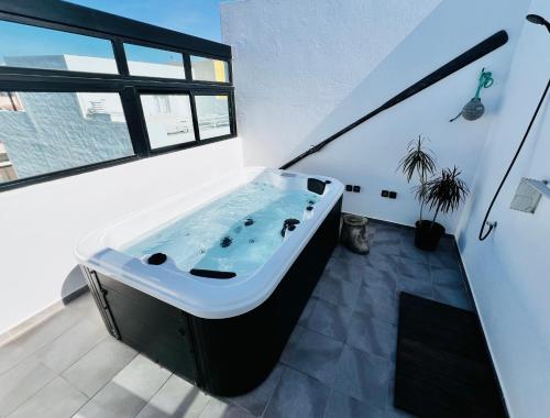 a large bath tub in a room with a window at Atlantic Green 3 Apartment, Terrace, Solarium and Spa in El Cotillo
