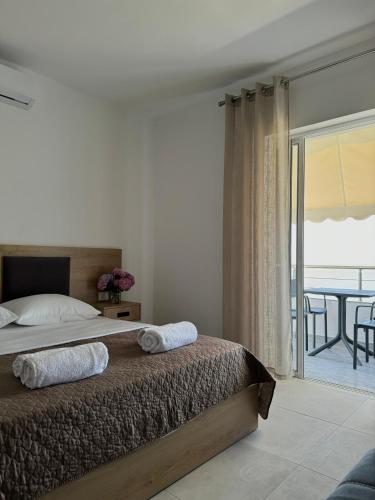 a bedroom with a bed with a view of a balcony at Tophill Apartments in Borsh