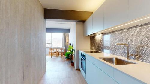 a kitchen with white cabinets and a sink at Alto-Tower Residence - Self Check In in Zurich