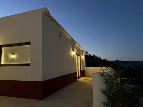 a white house with a door on the side of it at AlcaidariaVista in Ourém