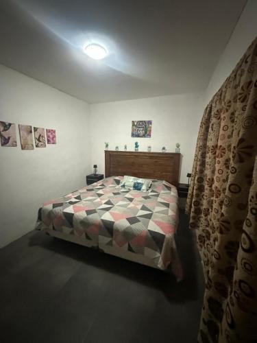 a bedroom with a bed with a checkered comforter at Hospedaje San Vicente in San Vicente
