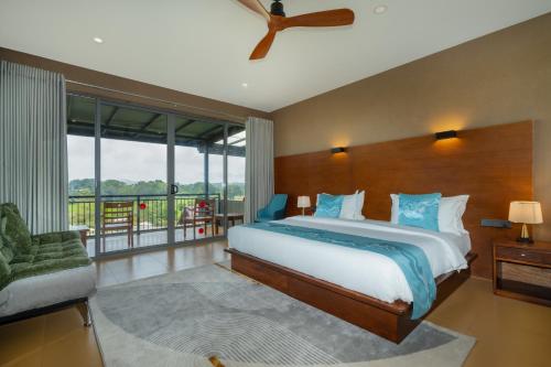 a bedroom with a large bed and a large window at Trio Lodge- Habarana in Habarana