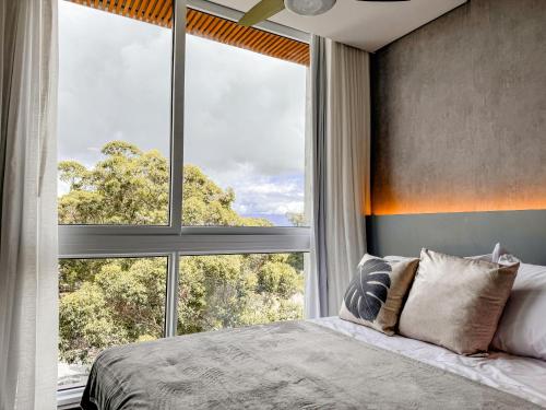 a bedroom with a bed and a large window at Livin517 in Xangri-lá