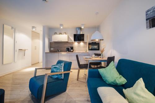 a living room with a blue couch and a table at Am Park 14 in Prerow