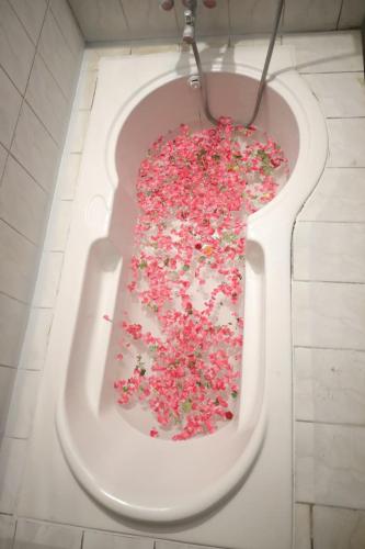 a bath tub filled with pink sprinkles in a bathroom at Hidden Pearl Beach Villa in Pondicherry