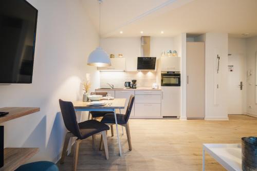 a kitchen and dining room with a table and chairs at Am Park 24 in Prerow