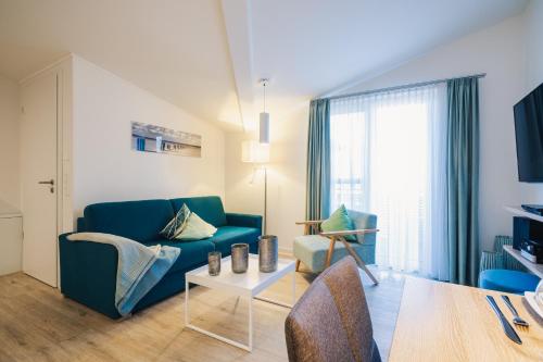 a living room with a blue couch and a table at Am Park 24 in Prerow