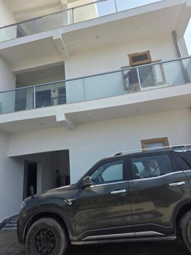 a black suv parked in front of a building at Bipl House Stay in Greater Noida