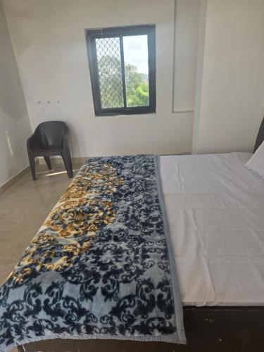 a bedroom with a bed with a black and white blanket at Bipl House Stay in Greater Noida