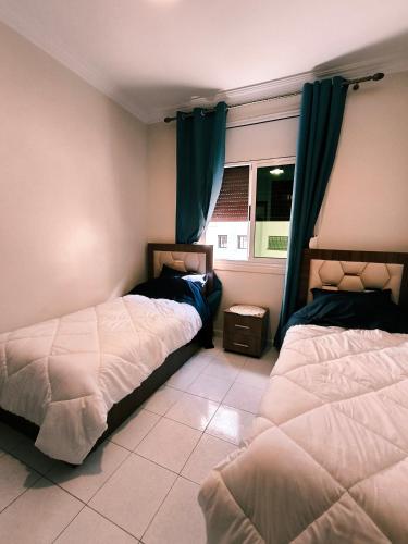 a bedroom with two beds and a window at Chez Atlas in Kenitra