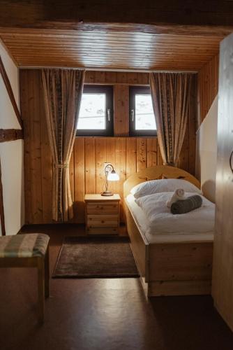 a bedroom with a bed and a lamp and a window at Haus Erlenau in Dalaas