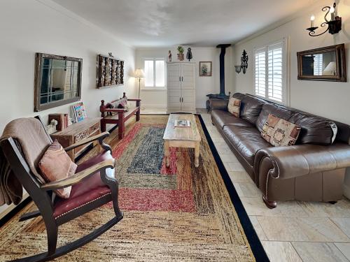 a living room with a leather couch and a coffee table at Casita de Jeanetta in Santa Fe