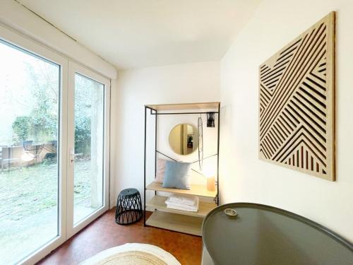 ein Badezimmer mit Spiegel, Badewanne und Fenster in der Unterkunft Le Conki ( Parking gratuit ) in Chartres