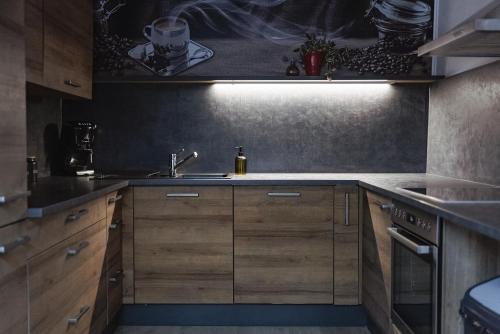 a kitchen with wooden cabinets and a sink at Haus Erlenau in Dalaas