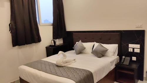 a bedroom with a bed with a white swan on it at DJ Imperial Suites in Trivandrum