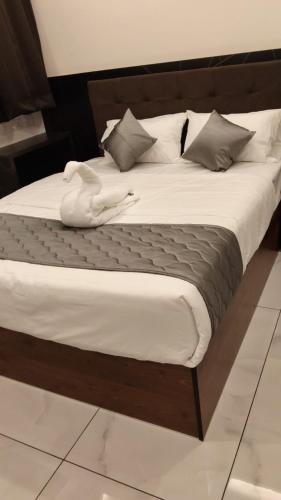 a large bed with white sheets and pillows at DJ Imperial Suites in Trivandrum