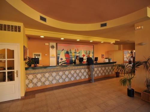 a man standing at a bar in a hotel lobby at Apartment in Empuriabrava by the Beach in Empuriabrava