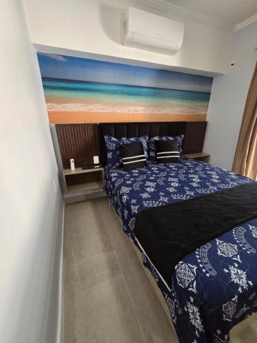 a bedroom with a bed with blue and white sheets at Casa Nova Marilea in Rio das Ostras