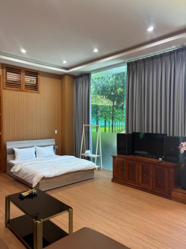 a bedroom with a bed and a flat screen tv at Tiến Đạt Villa in Vung Tau